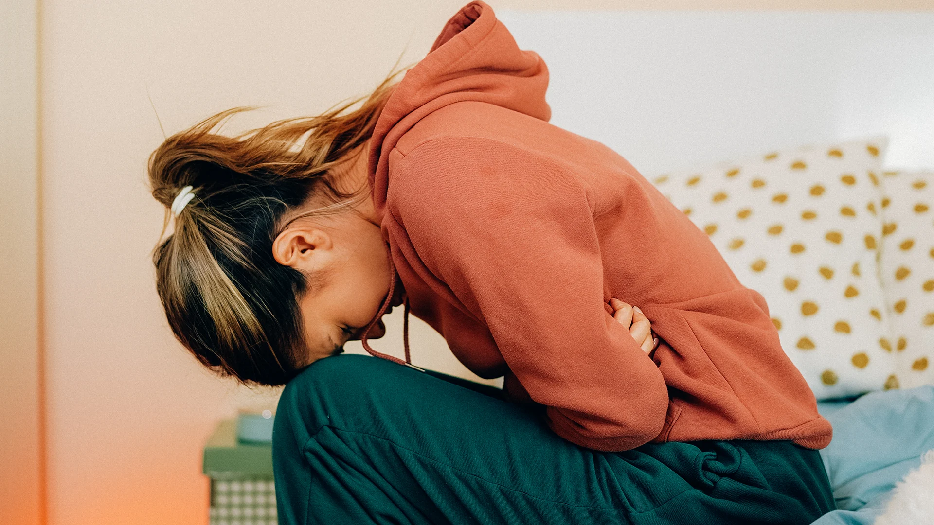 Woman leaning over because of painful gi symptoms.